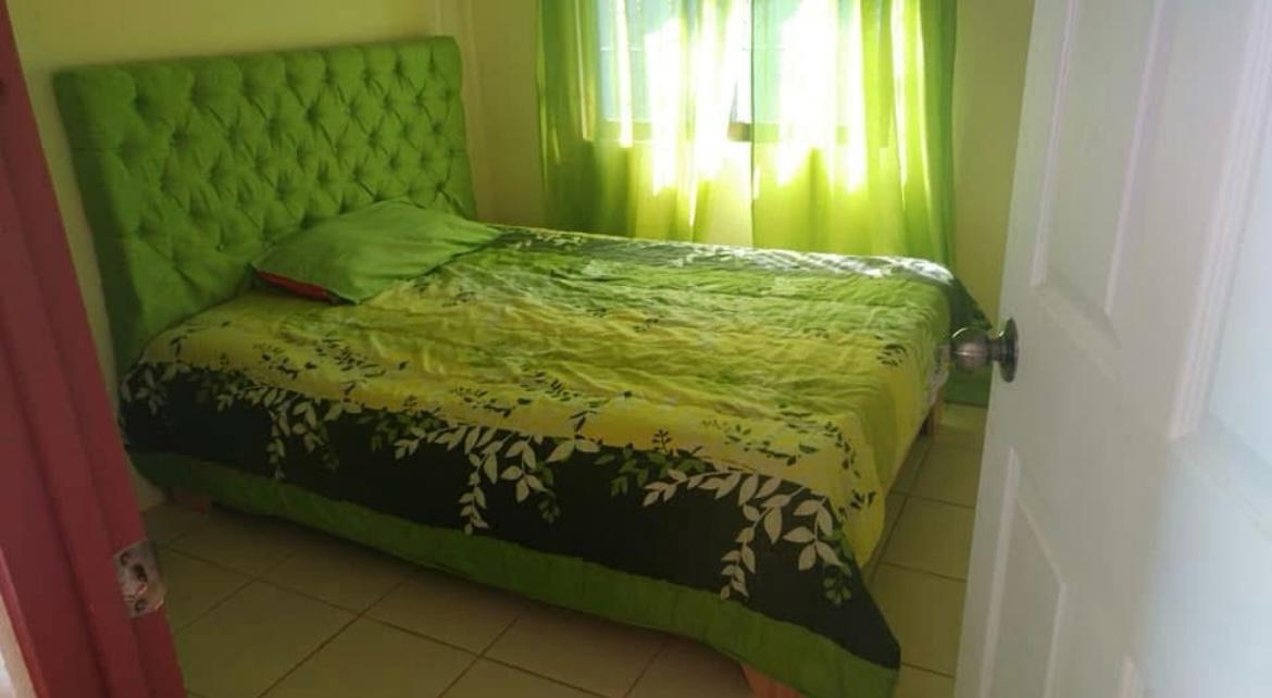 Habitación principal espaciosa con cama king size, luz natural y decoración moderna