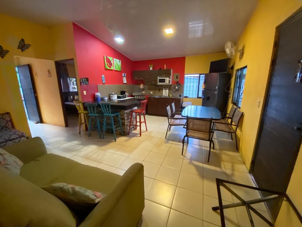 Cocina equipada con electrodomésticos modernos, encimeras blancas y comedor