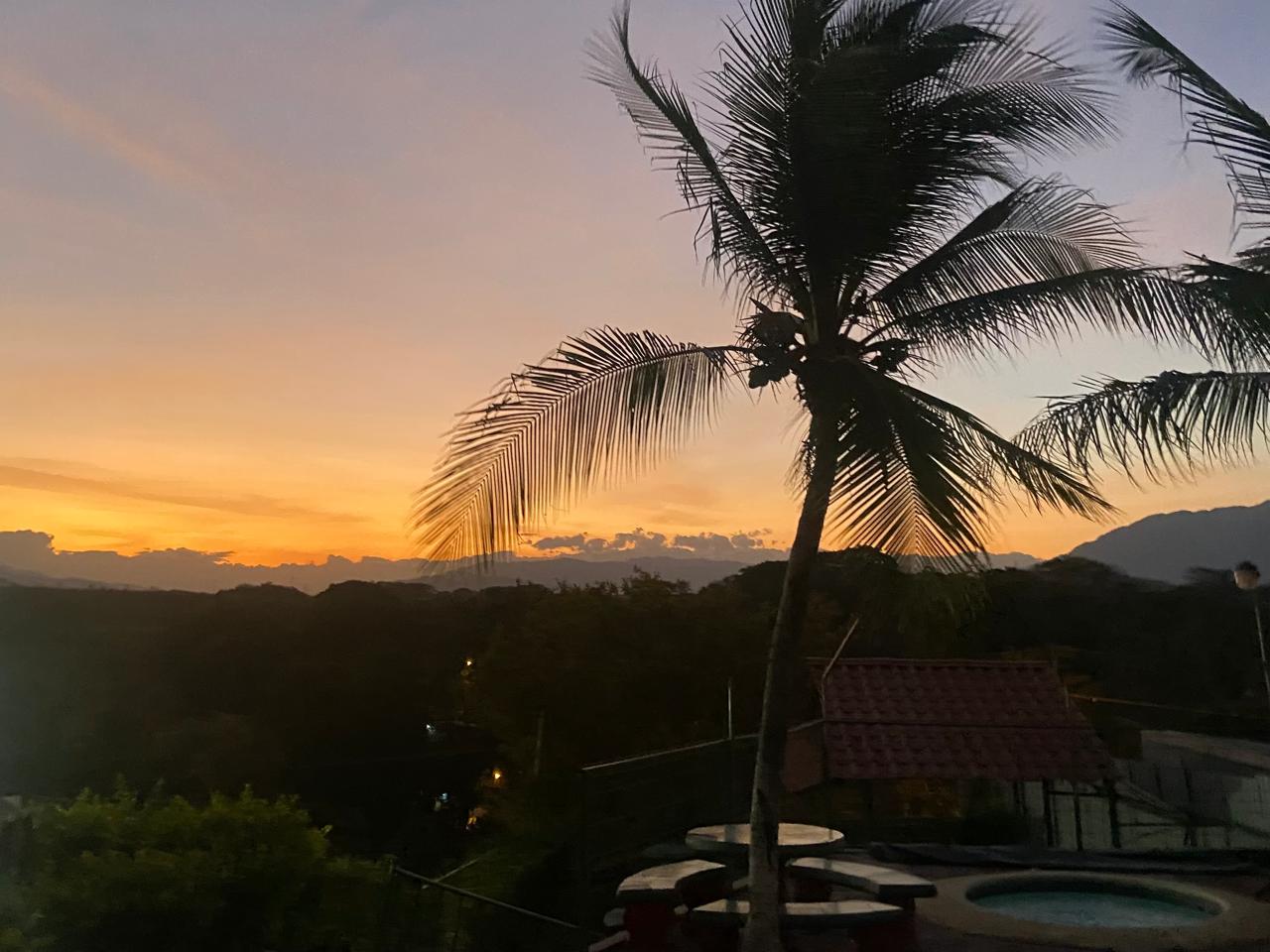 Piscina privada en Villa Orotina al atardecer con vista panorámica y cielos anaranjados