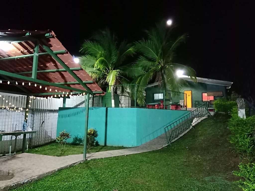 Zona BBQ con parrilla, mesa de comedor al aire libre y luces colgantes