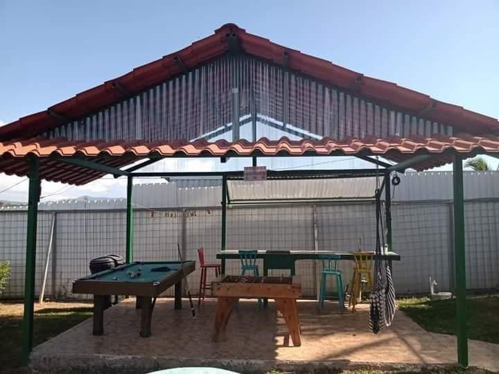 Zona BBQ con parrilla, mesa de comedor al aire libre y luces colgantes